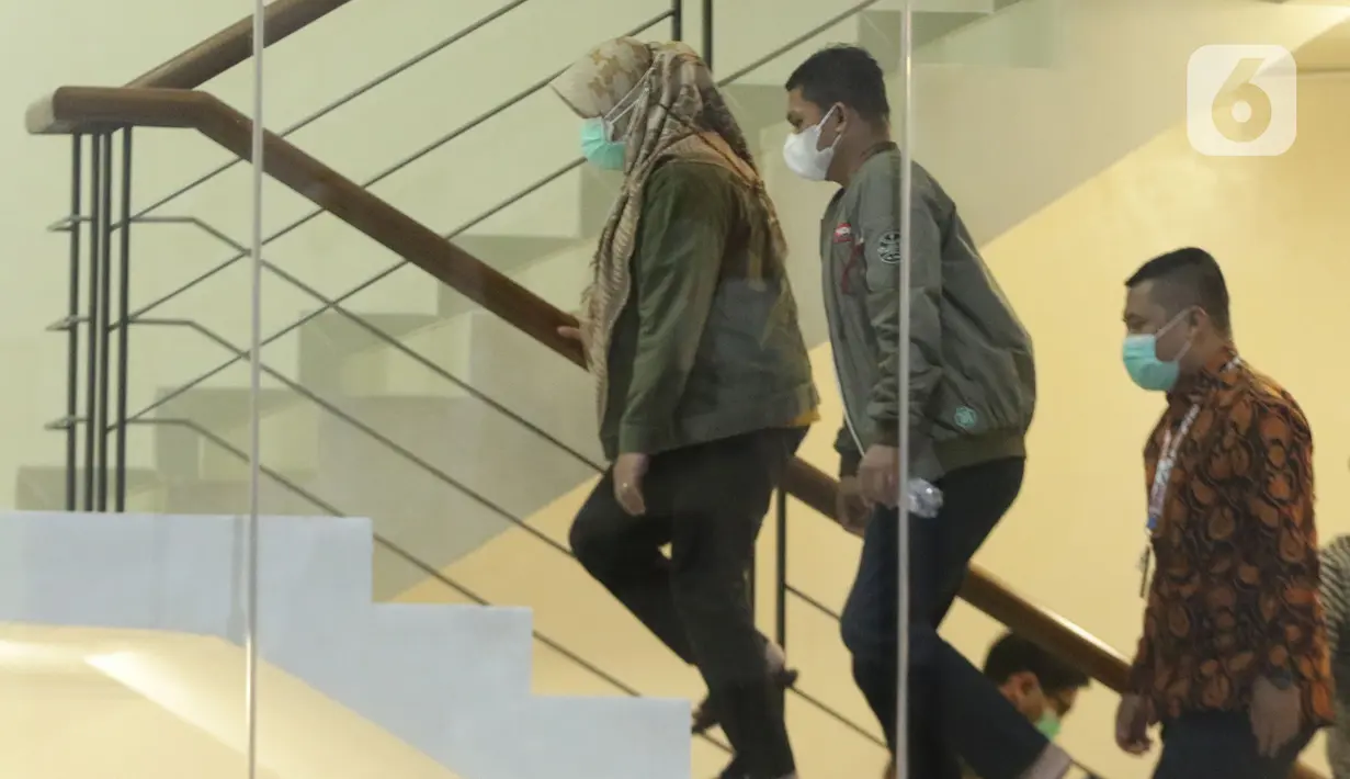 Bupati Kolaka Timur (Koltim) Sulawesi Tenggara, Andi Merya Nur (kiri) menaiki tangga saat tiba di Gedung KPK, Jakarta, Rabu (22/9/2021). Sebelumnya, Andi Merya Nur terjaring operasi tangkap tangan (OTT) KPK bersama lima orang lainnya pada Selasa (21/9) malam. (Liputan6.com/Helmi Fithriansyah)