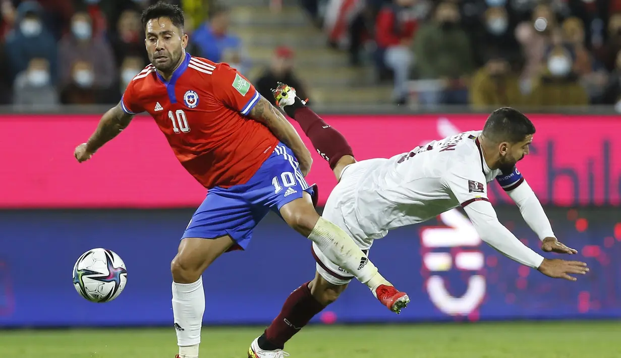 Pemain Chile Luis Jimenez (kiri) berebut bola dengan pemain Venezuela Tomas Rincon pada pertandingan kualifikasi Piala Dunia 2022 di Stadion San Carlos de Apoquindo, Santiago, Chile, Kamis (14/10/2021). Chile menang 3-0. (Claudio Reyes/Pool via AP)