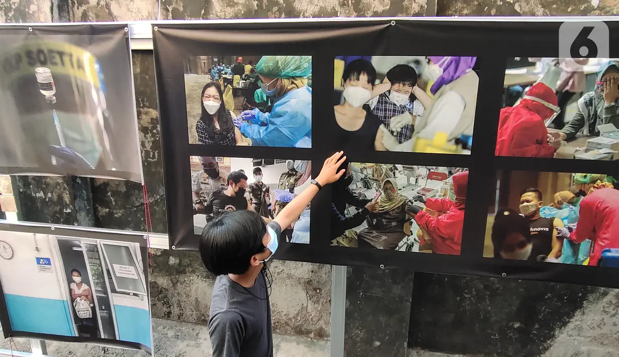 Warga melihat pameran foto jurnalistik karya pewarta foto Indonesia Tangerang di kawasan Pasar Lama, Tangerang, Minggu (30/5/2021). Pameran foto bertajuk meredanya Covid-19 ini bertujuan agar masyarakat dapat mengenal bahaya Covid-19 yang tengah mewabah di Indonesia.  (Liputan6.com/Angga Yuniar)