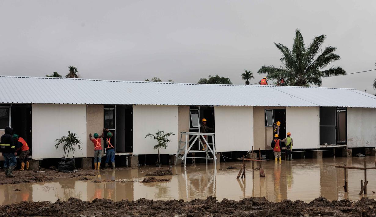 Hunian sementara tersebut dirancang sebagai solusi tempat tinggal selama masa transisi pemulihan. Tampak dalam foto, unit-unit perumahan sementara yang dibangun oleh Danantara, Badan Pengelola Investasi (BPI) strategis Indonesia, sedang dibangun untuk warga yang dievakuasi akibat banjir bandang, seiring dengan berlanjutnya pembangunan di 14 lokasi di Aceh Tamiang, provinsi Aceh, pada Kamis 8 Januari 2026. (ADITYA AJI/AFP)