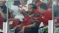 Presiden Joko Widodo berbincang dengan Menpora ketika menonton langsung final Piala Presiden 2018 antara Persija vs Bali United di Stadion Utama Gelora Bung Karno, Senayan, Jakarta, Sabtu (17/2) (Liputan6.com/Arya Manggala)