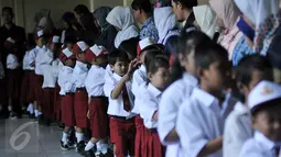 Siswa melakukan halalbilahal usai mengikuti upacara di SDN Manggarai 17 Pagi, Jakarta, Senin (18/7). Hari pertama sekolah diisi dengan kegiatan halalbilahal dan pengenalan siswa dan orang tua dengan lingkungan pendidikan. (Liputan6.com/Johan Tallo)