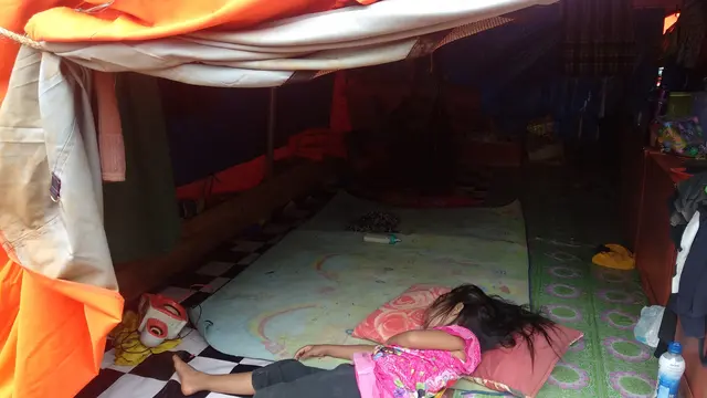 Seorang bocah yang tertidur di tenda pengungsi banjir Konawe Utara.(Liputan6.com/Ahmad Akbar Fua)