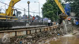 Petugas Sudin Kebersihan DKI Jakarta menurunkan alat berat untuk mengangkut sampah yang menumpuk di jembatan Kampung Melayu, Jatinegara, Jakarta Timur, Minggu (3/4/2016). (Liputan6.com/Yoppy Renato)