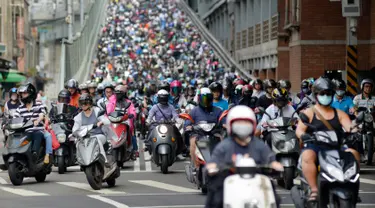 Pengendara sepeda motor melintasi Jembatan Taipei pada jam sibuk pagi hari, China (21/5). Sebelumnya telah beredar sebuah video mengejutkan mengenai kondisi sebuah jalan yang dipenuhi oleh antrean motor. (AFP Photo/Chris Stowers)