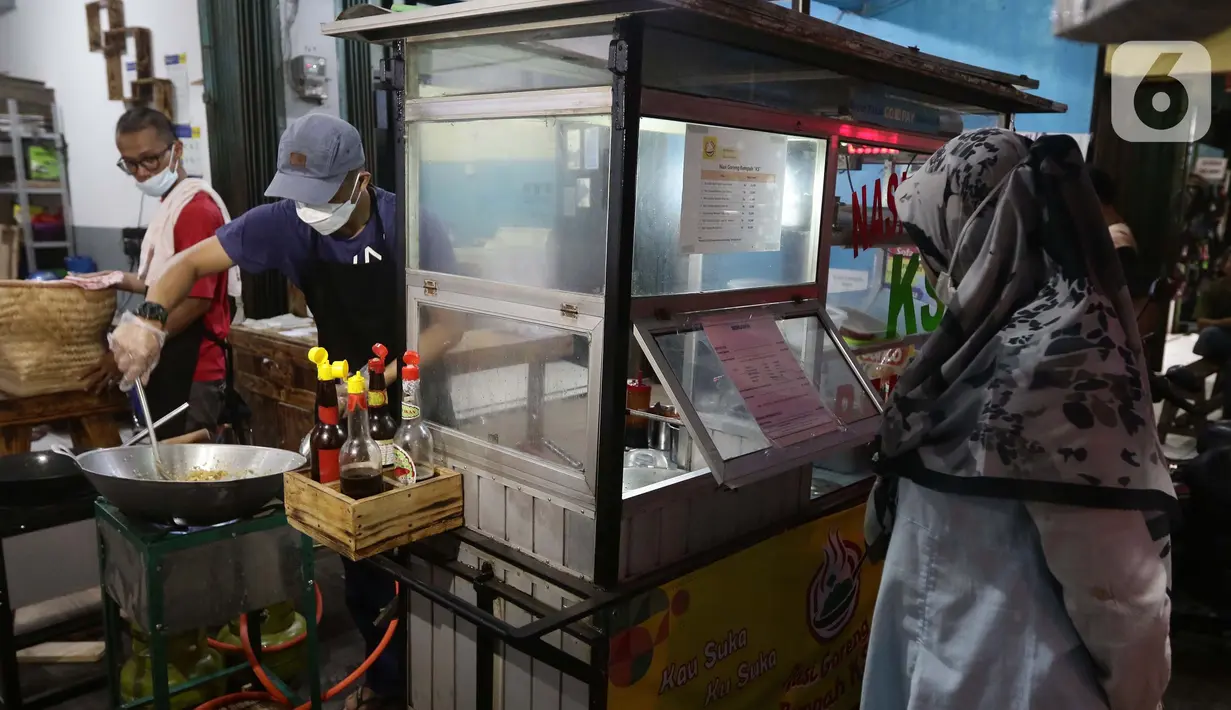 Mantan pegawai fungsional Biro Hukum KPK, Juliandi Tigor Simanjuntak memasak nasi goreng pesanan pelanggan di Jalan Raya Hankam, Bekasi, Rabu (13/10/2021). Sejumlah pegawai KPK yang dipecat kini beralih profesi. (Liputan6.com/Helmi Fithriansyah)