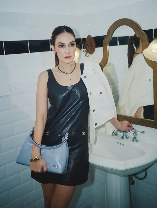 Di pemotretan terbaru, Luna Maya tampil memukau dengan mini leather dress berwarna hitam tanpa lengan. Ia padukan penampilannya dengan denim jacket berwarna putih dan tas kulit bernuansa biru. [Foto: Instagram/lunamaya]