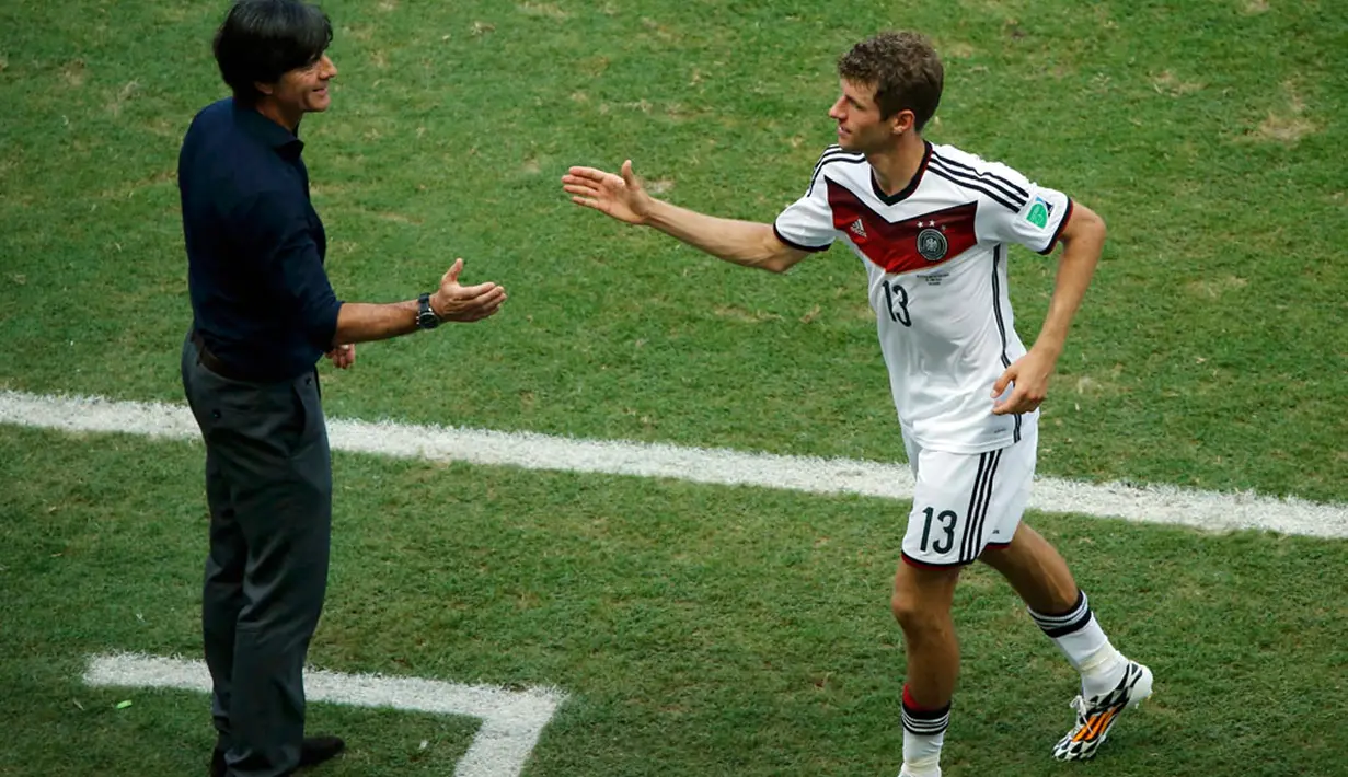 Pelatih Timnas Jerman, Joachim Loew (kiri) terlihat memberikan ucapan selamat kepada Thomas Mueller yang berhasil membawa Jerman meraih poin penuh di laga penyisihan Piala Dunia 2014, (16/6/2014). (REUTERS/Fabrizio Bensch) 