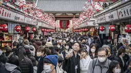 Orang-orang mengunjungi kuil Sensoji menjelang liburan Tahun Baru di Tokyo pada 30 Desember 2022. Kuil Sensoji dikenal sebagai tempat wisata paling terkenal di Tokyo. (AFP/Yuichi Yamazaki)