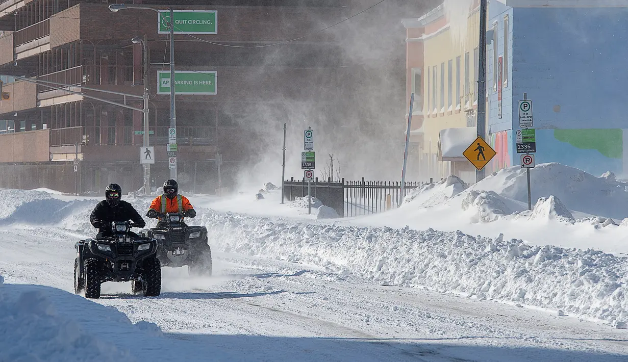 Warga mengendarai all-terrain saat salju tebal menyelimuti Kota St John's, Newfoundland, Kanada, Sabtu (18/1/2020). St John's menghadapi keadaan darurat ketika salju tebal memaksa pusat-pusat bisnis tutup dan kendaraan dilarang melintas di jalan raya. (Andrew Vaughan/The Canadian Press via AP)