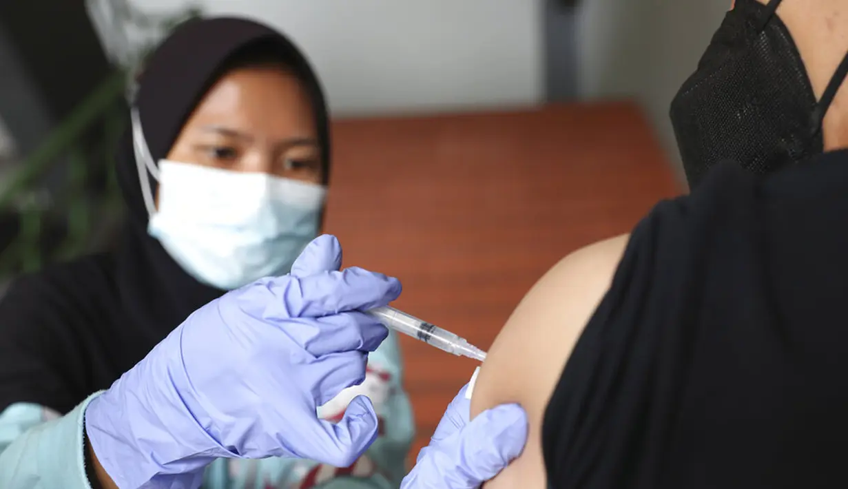 Warga menerima suntikan vaksin virus corona COVID-19 Sinovac di Stadion Patriot Candrabhaga, Bekasi, Kamis (28/10/2021). Indonesia melihat ke depan dengan waspada akan gelombang ketiga COVID-19 selama perjalanan liburan yang akan datang. (AP Photo/Achmad Ibrahim)