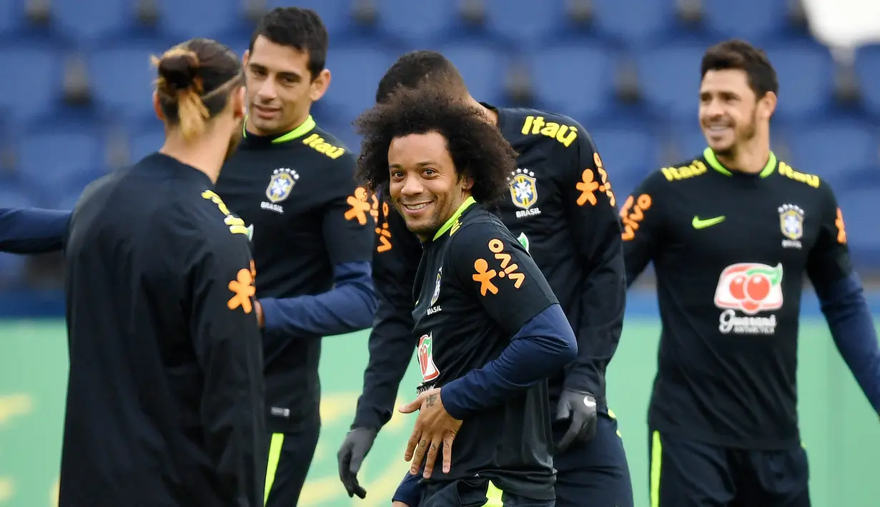 Bek Brasil, Marcelo, tersenyum saat sesi latihan jelang laga persahabatan di Paris, Rabu (8/11/2017). Brasil akan berhadapan dengan Jepang. (AFP/Franck Fife)