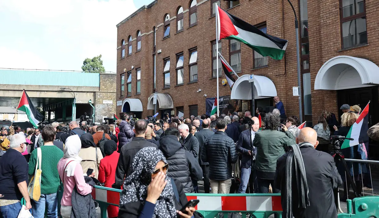Orang-orang menghadiri upacara pengibaran bendera Palestina di luar Kedutaan Besar Palestina di London Barat, Inggris, pada 22 September 2025. (Adrian DENNIS/AFP)