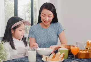 Ibu yang menyendoki anaknya makan (Foto: Freepik/tirachardz).