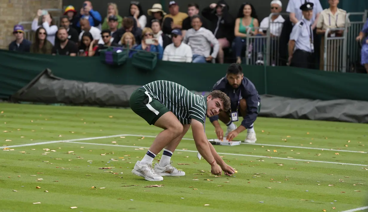 Mereka menaburkan confetti oranye dan potongan puzzle di atas rumput. (AP Photo/Alastair Grant)