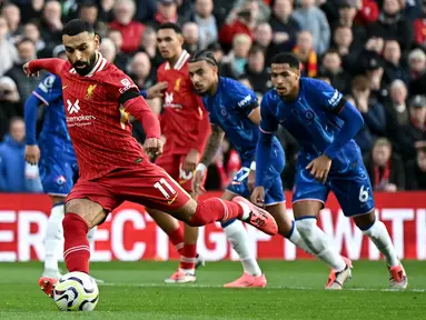 Pemain Liverpool, Mohamed Salah mencetak gol melalui eksekusi tendangan penalti pada laga lanjutan Liga Inggris 2024/2025 melawan Chelsea di Anfield, Liverpool, Inggris, Minggu (20/11/2024). (AFP/Paul Ellis)