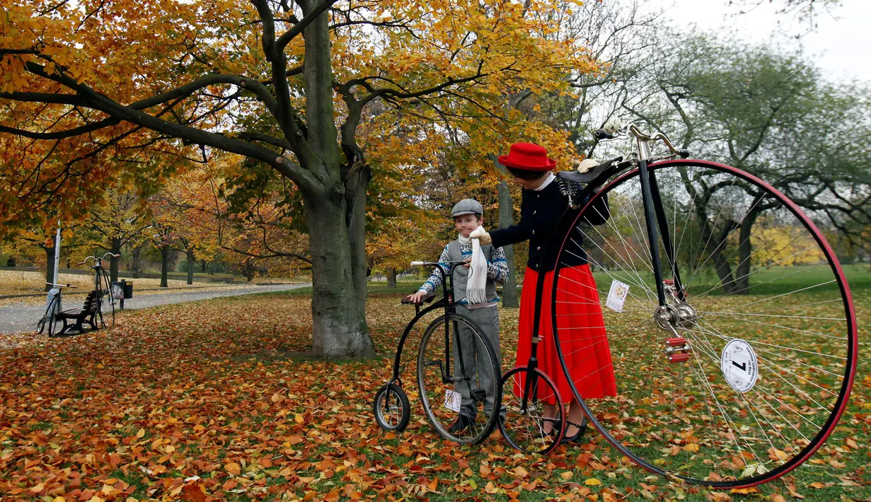 Seorang ibu dan anaknya bersiap menghadiri balapan sepeda Penny Farthing tahunan di Praha, Republik Ceko (5/11). Sepeda ini sangat populer pada tahun 1880an, dan merupakan sepeda pertama yg mendapat sebutan Bicycle (dua roda). (Reuters/David W Cerny)