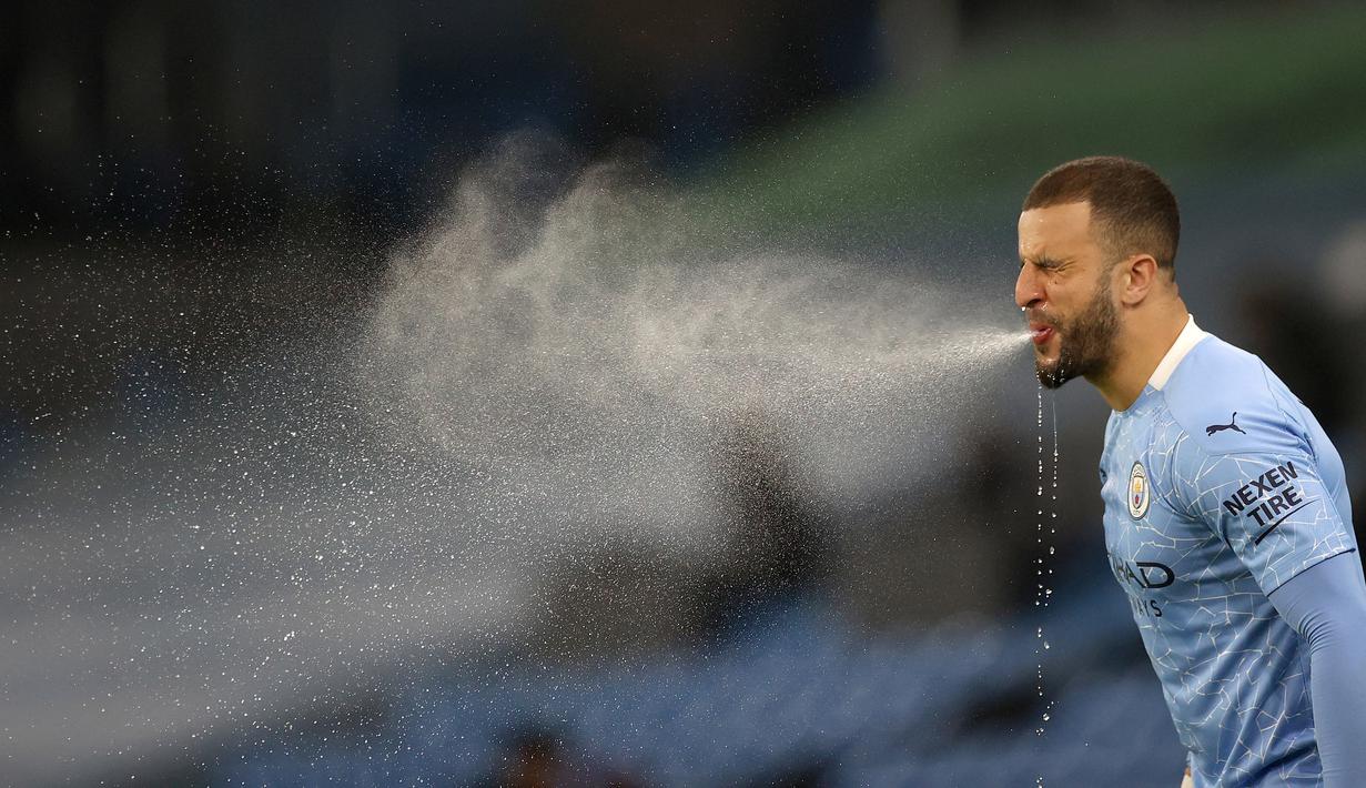 Pemain Manchester City, Kyle Walker menyemburkan air dari mulutnya saat pertandingan lanjutan Liga Inggris melawan Wolverhampton Wanderers. (Foto: AFP/Pool/Carl Recine)