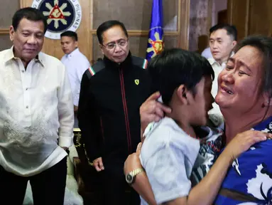 Seorang anak memeluk ibunya di Istana Malacanang, Manila, Filipina, Selasa (28/2). Presiden Filipina Rodrigo Duterte berhasil mempersatukan kembali orangtua dan anaknya usai diculik oleh kelompok Abu Sayyaf. (AP Photo)