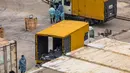 Pekerja bersiap memindahkan jenazah dari truk ke kontainer berpendingin di Rumah Sakit Umum Fu Shan, Hong Kong, Rabu (16/3/2022). Kasus COVID-19 terburuk yang melanda Hong Kong menimbulkan kepanikan serta membuat rumah sakit dan kamar jenazah penuh. (DALE DE LA REY/AFP)
