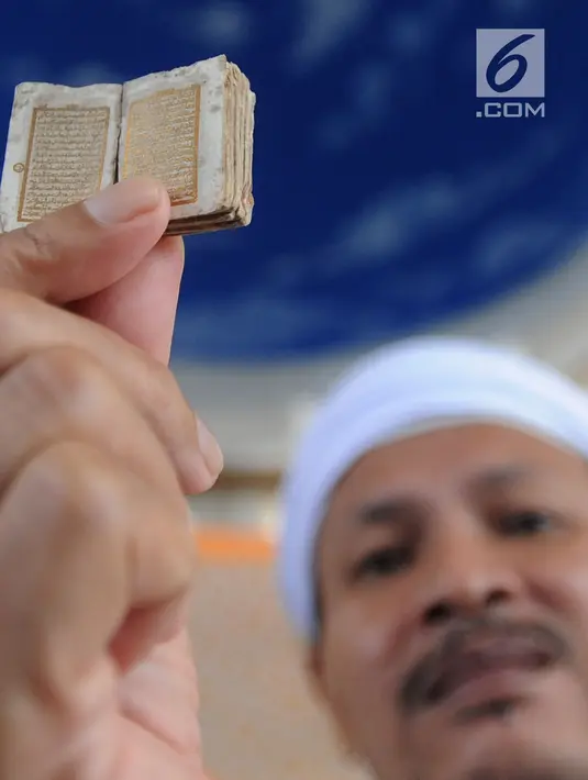 Kyai Tubagus Muhammad Tamyiz menunjukkan Alquran mini bertinta emas di Masjid Jami Darusalam, Bogor, Kamis (24/5). Alquran mini tersebut benda bersejarah peninggalan pahlawan zaman kolonial, Pangeran Wijaya Kusuma. (Merdeka.com/Arie Basuki)