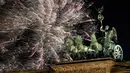 Pesta kembang api menyemarakkan perayaan malam Tahun Baru 2019 di atas Gerbang Brandenburg, Berlin, Jerman, Selasa (1/1). (AP Photo/Michael Sohn)