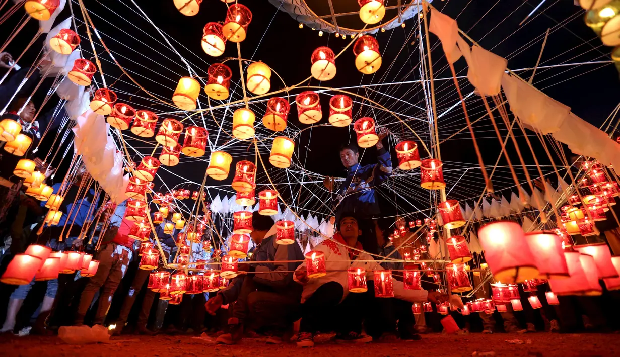 Sejumlah warga menyalakan lilin dan bersiap melepaskan lampion buatan tradisional ke langit selama festival tahunan Tazaungdaing di Taunggyi, Myanmar (19/11). (REUTERS/Soe Zeya Tun)