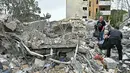 Sebagian besar pengungsi hidup dengan akses kebutuhan pokok yang terbatas. Tampak dalam foto, warga memeriksa puing-puing bangunan yang hancur saat kembali ke kota Nabatieh, Lebanon Selatan pada Sabtu 18 April 2026. (FADEL itani/AFP)