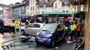 Petugas pemadam kebakaran berusaha mengevakuasi bus sekolah yang menabrak tembok sebuah toko di Eberbach dekat Mannheim, Jerman, Selasa (16/1). Polisi mulai melakukan penyelidikan untuk mencari tahu penyebab kecelakaan. (Rene Priebe/dpa via AP)