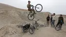 Aksi pemuda Afganistan, melakukan lompatan tinggi disaksikan teman-temannya menggunakan sepeda Dirt Jump (DJ) di Kabul, Afghanistan (20/11). Jenis Dirt Jump ini memiliki fungsi yang mirip dengan BMX .(Reuters/Omar Sobhani)