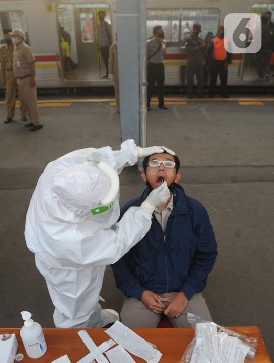 Paramedis mengambil sampel penumpang KRL Commuter Line saat tes swab di Stasiun Bojonggeder, Jawa Barat, Senin (11/05/2020).  Pemkab Bogor  melakukan tes swab  dan rapid test bagi penumpang KRL Commuter Line  dilakukan secara massal. (merdeka.com/Arie Basuki)