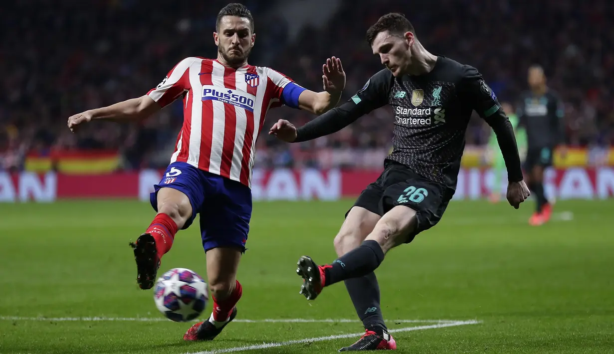 Bek Liverpool, Andrew Robertson berusaha mengumpan bola dari kawalan gelandang Atletico Madrid, Koke pada pertandingan leg pertama babak 16 Liga Champions di stadion Wanda Metropolitano di Madrid, Spanyol, Selasa (18/2/2020). Atletico Madrid menang tipis atas Liverpool 1-0. (AP Photo/Manu Fernandez)