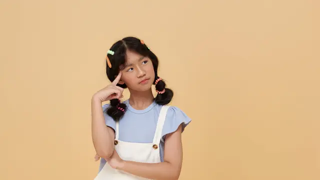 Seorang anak perempuan sedang berpikir sambil memegang dahinya dengan telunjuk (Foto Dok: Freepik/our-team)