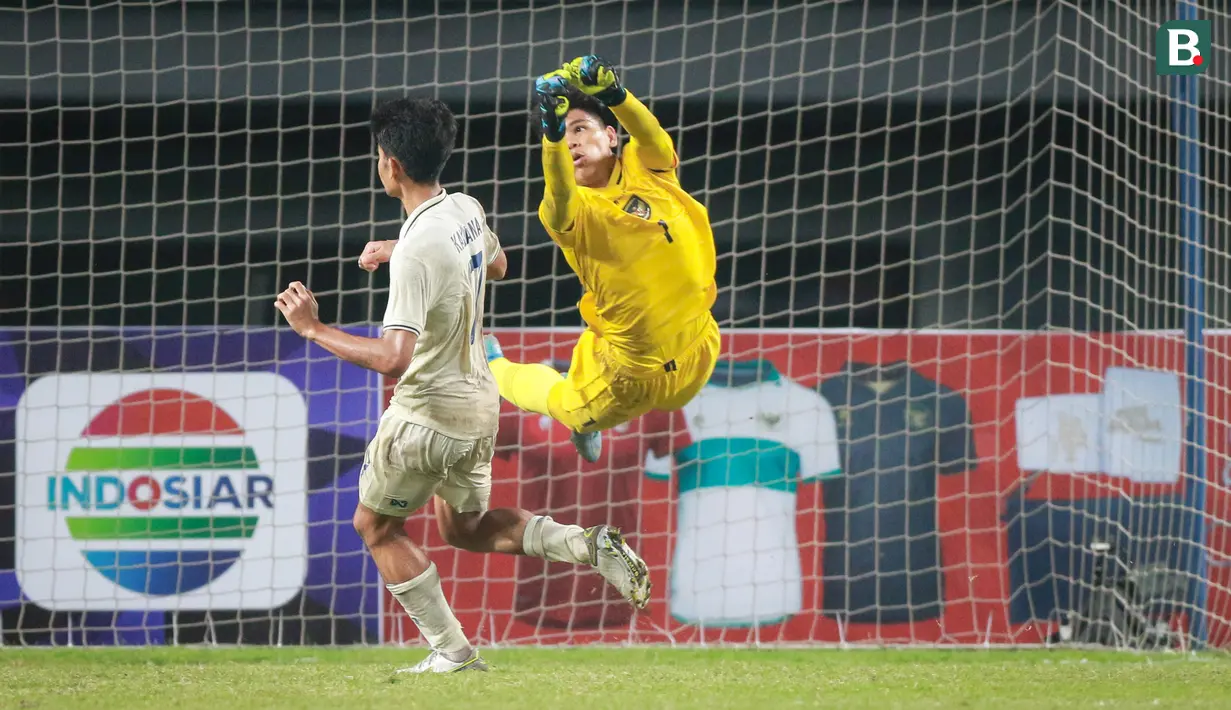 Kiper Timnas Indonesia U-19, Cahya Supriadi berusaha menghalau bola saat matchday ketiga Grup A Piala AFF U-19 2022 antara Timnas Indonesia U-19 melawan Timnas Thailand U-19 di Stadion Patriot Candrabhaga, Bekasi, Jawa Barat, Rabu (06/07/2022). (Bola.com/Bagaskara Lazuardi)