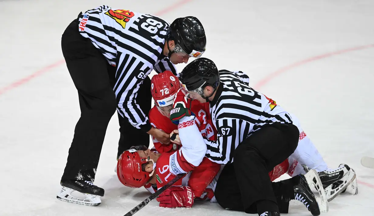 Wasit memisahkan pemain Hoki Es Rusia Emil Galimov (tengah) usai menjegal pemain depan Belarusia Geoff Platt (kiri) dalam pertandingan babak penyisihan grup A Kejuaraan Dunia Hoki Es Pria IIHF di Latvia, pada 1 Juni 2021. (Foto: AFP/Gints Ivuskans)