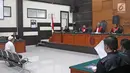 Terdakwa kasus penembakan dr Letty Sultri, dr Helmi mendengarkan dakwaan yang dibacakan oleh JPU di PN Jakarta Timur, Kamis (29/3). Helmi menjalani sidang perdana dengan agenda pembacaan surat dakwaan oleh JPU. (Liputan6.com/Herman Zakharia)