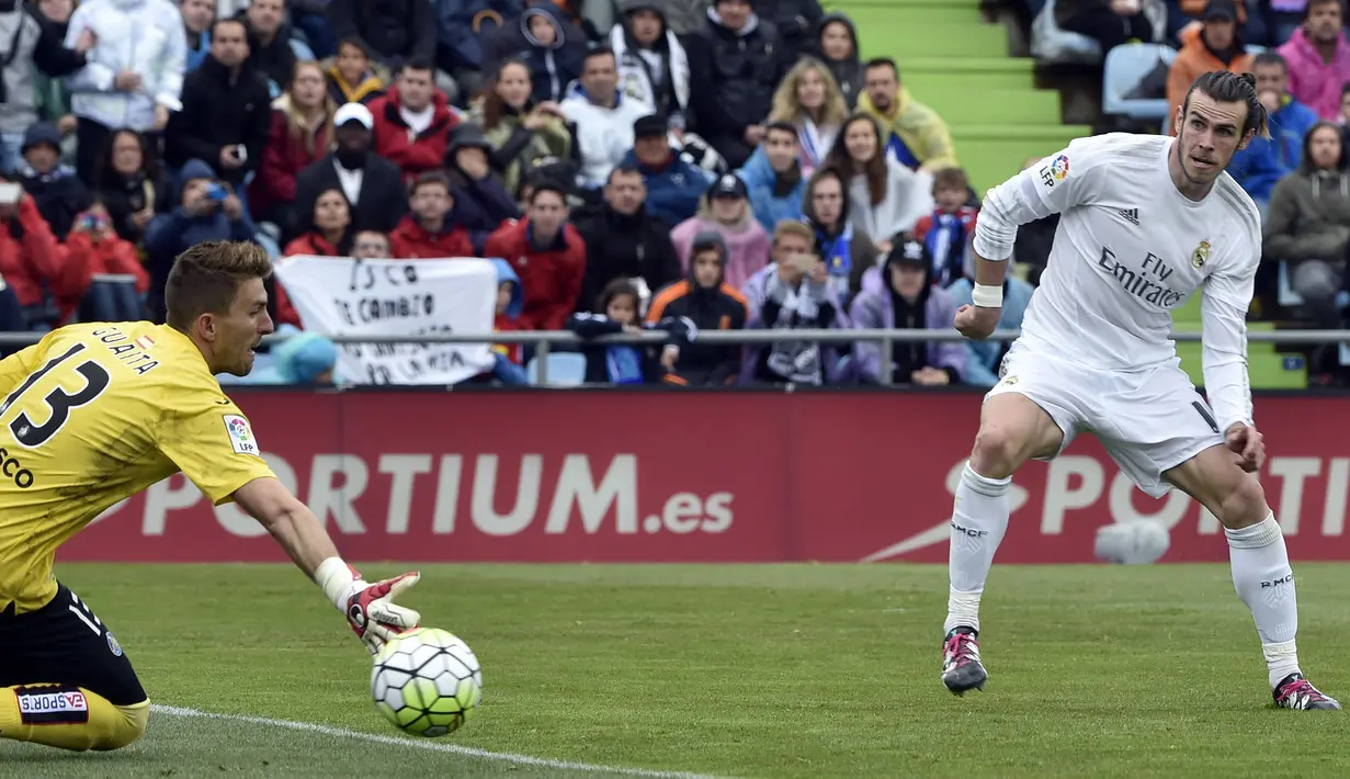 Gareth Bale saat mengecoh kiper Getafe Vicente Guaita pada lanjutan La Liga Spanyol di Stadion Colisseum Alfonso Perez, Getafe, Sabtu (16/4/2016) malam WIB. (AFP/Gerard Julien)
