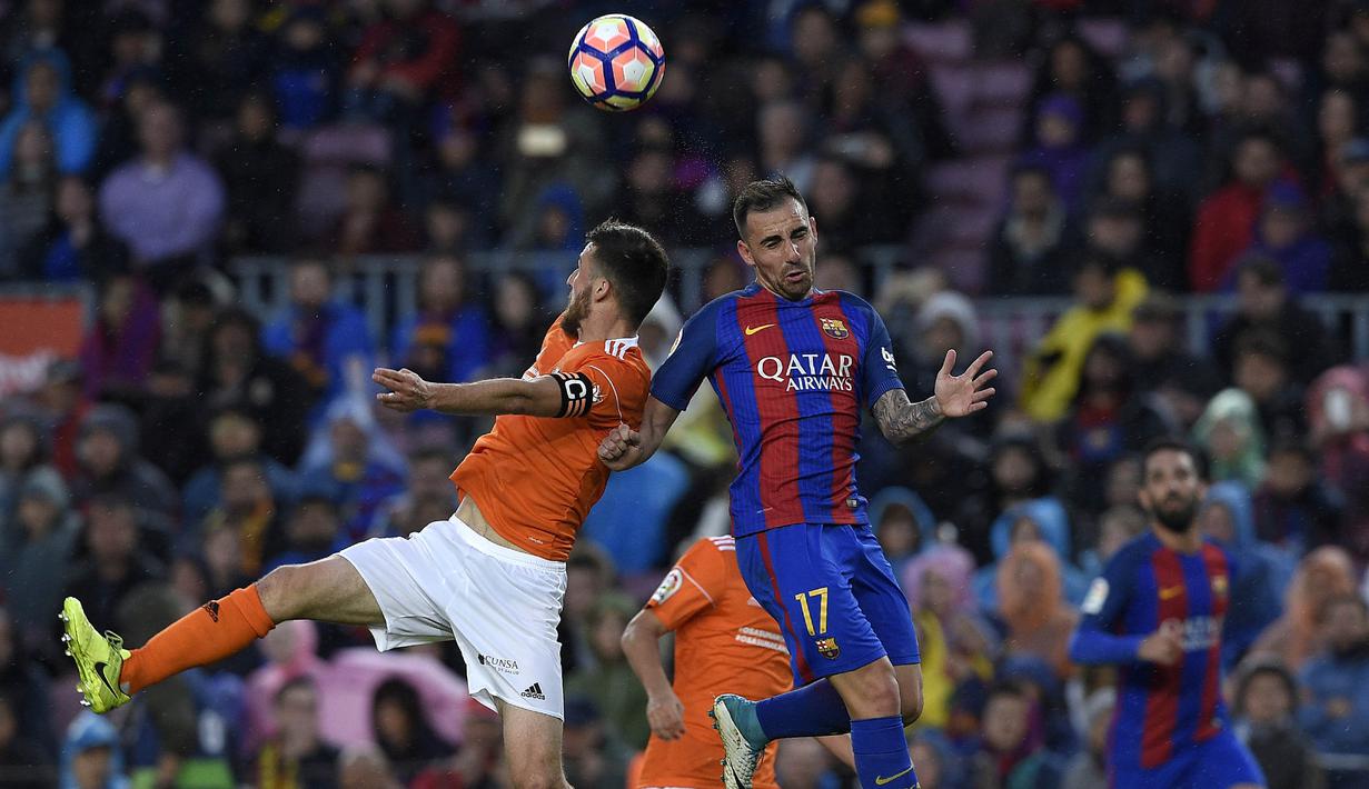 Striker Barcelona, Paco Alcacer, duel udara dengan bek Osasuna, Oier,  pada laga La Liga di Stadion Camp Nou, Barcelona, Rabu (26/4/2017). Barcelona menang 7-1 atas Osasuna. (AFP/Lluis Gene)