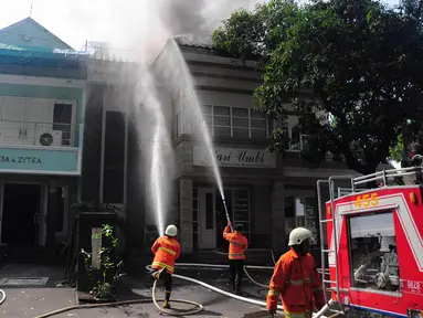 Petugas berusaha memadamkan kobaran api yang menghanguskan Restoran Kari Umbi di Jakarta, Jumat (4/7/14). (Liputan6.com/Faizal Fanani)