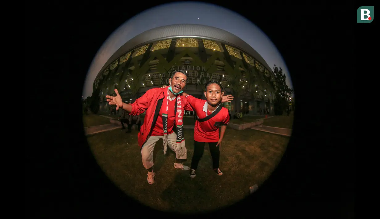 Ariso Bari (52) dan Arjuna (12) merupakan bapak dan anak yang langsung datang ke Stadion Candrabhaga untuk mendukung Timnas Indonesia U-19 di ajang Piala AFF U-19 2022. Begini tanggapan pria yang berprofesi sebagai pegawai negeri sipil dan bocah yang duduk di bangku SMP tersebut: "Progres di Timnas Indonesia U-19 bagus, tinggal kedepannya ditingkatkan lagi latihannya. Selain itu, jangan sering-sering diacak untuk posisi pemainnya." (Bola.com/Bagaskara Lazuardi)