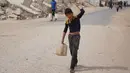 Saat ini, di antara infrastruktur yang runtuh dan sumber daya yang menipis, warga Gaza bergantung pada bantuan air terbatas, yang distribusinya sering terhambat oleh situasi keamanan. Tampak dalam foto, seorang pemuda Palestina membawa wadah air di Kota Gaza, Selasa 12 Mei 2026. (AP Photo/Abdel Kareem Hana)