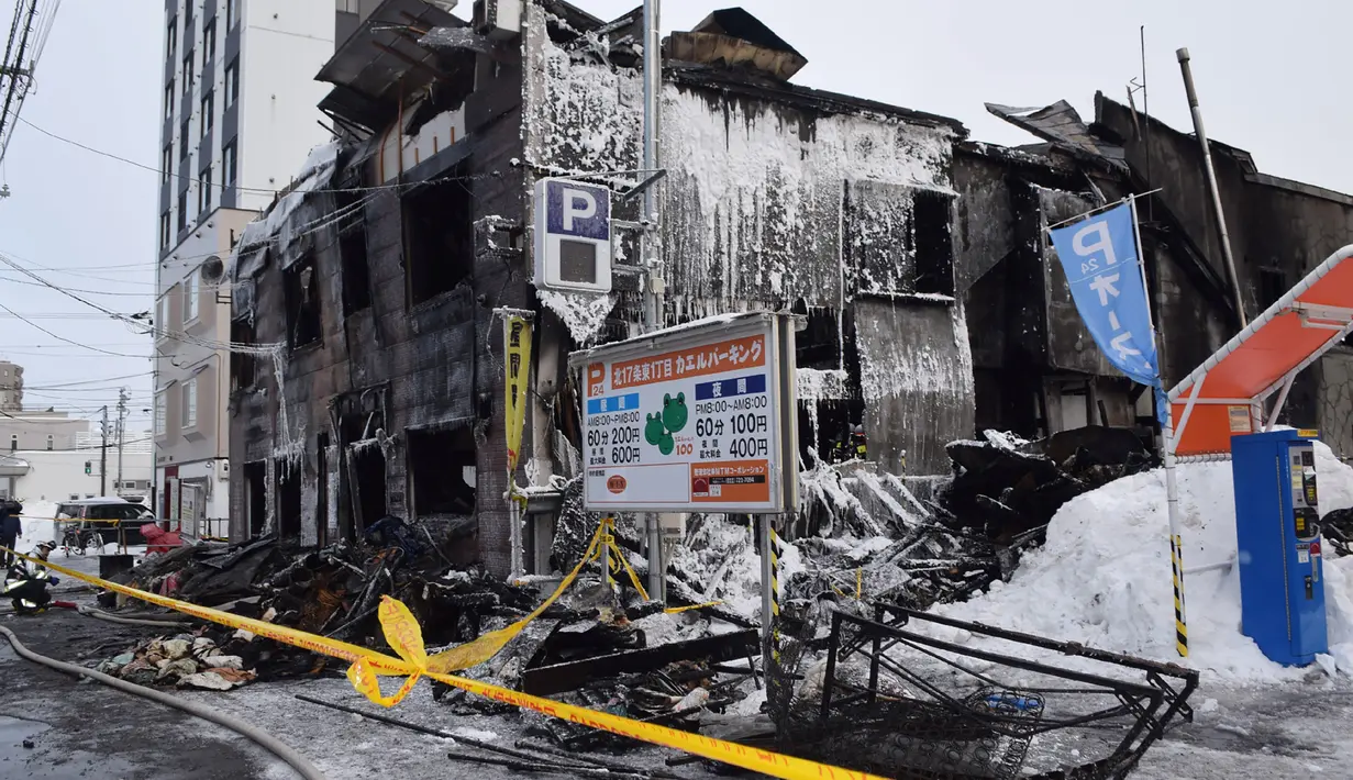 Garis polisi terpasang di depan sebuah panti jompo yang hangus dalam kebakaran di Sapporo, utara Jepang, Kamis (1/2). Pantai jompo tiga lantai dan terbuat dari kayu itu didirikan oleh organisasi sosial lokal Sapporo. (JIJI PRESS / AFP)
