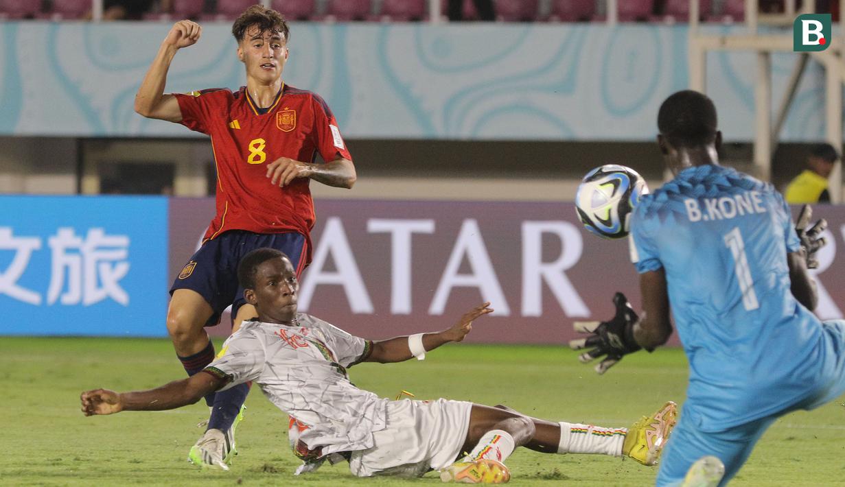 <p>Tendangan pemain Timnas Spanyol U-17, Roberto Martin (kiri) digagalkan oleh kiper Mali U-17, Bourama Kone dalam pertandingan babak penyisihan Grup B Piala Dunia U-17 di Stadion Manahan, Solo. Senin (13/11/2023). (Bola.com/Arief Bagus)</p>