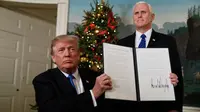 Presiden AS Donald Trump menunjukkan dokumen pengumuman Yerusalem sebagai ibukota Israel yang telah ditandatangani di Ruang Penerimaan Diplomatik Gedung Putih, Washington, Rabu (6/12). (AP Photo / Evan Vucci)