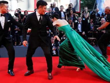 Aktris Korsel, Moon So-ri tiba-tiba kehilangan keseimbangan ketika melenggang di karpet merah pemutaran perdana film The Light Between Two Ocean di Venice Film Festival, Italia, Kamis (1/9). (REUTERS/Alessandro Bianchi)