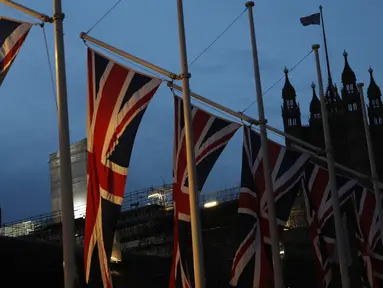 Bendera Inggris berkibar dengan latar Istana Westminster terlihat di London, Sabtu, (1/2/2020).  Mulai 1 Februari 2020 ini, Inggris secara resmi telah meninggalkan Uni Eropa (UE) setelah lebih dari tiga tahun referendum yang membuat negara itu terpecah belah. (AP Photo/Alastair Grant)