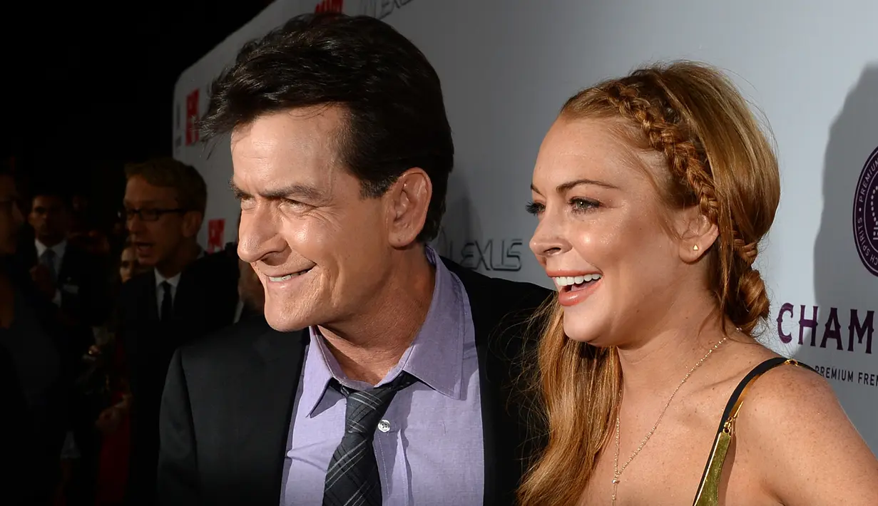Charlie Sheen dan Lindsay Lohan saat akan menonton pemutaran perdana "Scary Movie 5" di Hollywood, AS. (11/4/2013). Dalam acara televisi Today yang disiarkan NBC pada Selasa (17/11/2015) Charlie Sheen mengaku mengidap HIV. (AFP Photo)