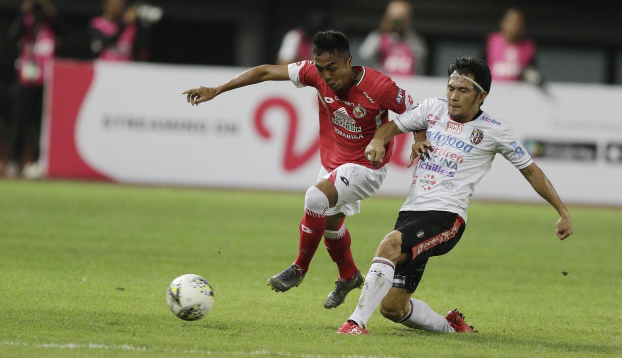 Bek Bali United, Micheal Orah, berebut bola dengan pemain Semen Padang, Dedi Hartono, pada laga Piala Presiden 2019 di Stadion Patriot, Jawa Barat, Senin (11/3). Bali United menang 2-1 atas Semen Padang. (Bola.com/M Iqbal Ichsan)
