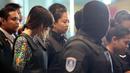 Tersangka kasus pembunuhan Kim Jong-nam, Siti Aisyah dan Doan Thi Huong, dikawal polisi menuju Bandara Internasional Kuala Lumpur, Selasa (24/10). Keduanya melakukan reka ulang kejadian di tempat keduanya dituding meracuni Kim Jong-nam. (AP/Sadiq Asyraf)