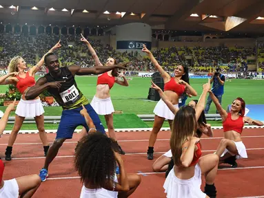 Pelari Usain Bolt melakukan selebrasi menari bersama wanita-wanita cantik di Stadium Louis II, Monaco, (21/7). Usain Bolt asal Jamaika menjuarai kejuaaran atletik lari 100m Diamond League. (AFP Photo/Yann Coatsaliou)